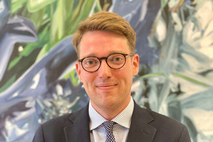 prof. Vetter hat blonde kurze Haare und trägt eine Brille. Er trägt ein Anzug mit Krawatte.