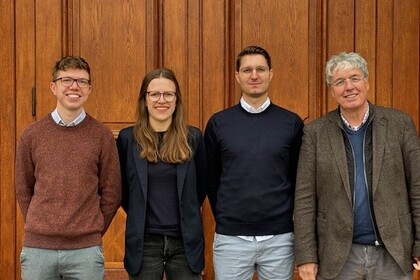 The M2Olie Research team, consisting of four persons, stands in front of the Mannheim Palace.