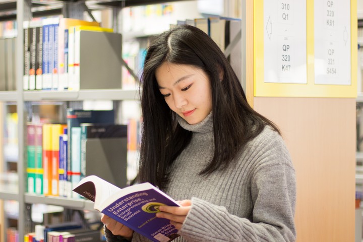 Studentin liest in Buch