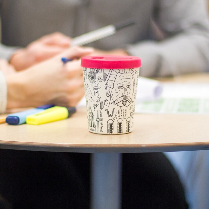 Tisch mit Kaffeebecher und Textmarkern