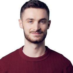 Kai Irion has short hair and a beard and wears a red top