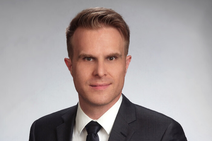 Prof. Stahl hat kurze Haare und trägt Anzug und Krawatte.