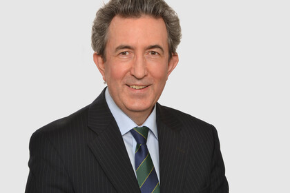 Prof. Albrecht hat kurze graue Haare und trägt einen dunklen Anzug mit Krawatte.
