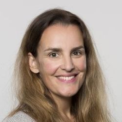 Eine Frau mit langen dunkelblonden Haaren lächelt.
