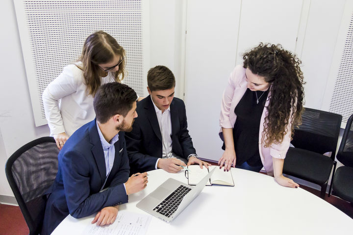 Vier Personen um Tisch mit Laptop